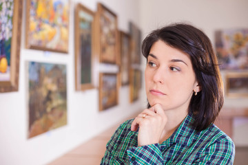 Young woman looking at painting.