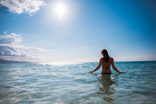 Eine junge Frau schwimmt  in der Karibik auf der Jamaika
