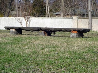 very long stone bench, surrounded by grass, made of very large stone blocks