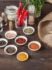 Spices and herbs. Variety of spices and herbs on a dark wooden surface
