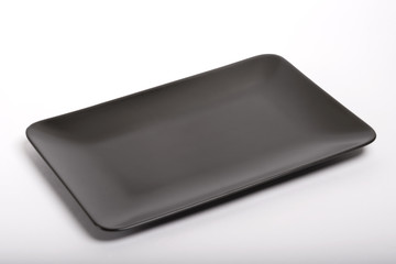 Empty black plate on an isolated white background. View from above.