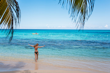 Fototapeta na wymiar Eine junge Frau spaziert am Strand in der Karibik auf Jamaika 