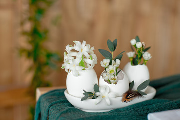 Easter Egg Flower Vases decorated with flowers on green tablecloth