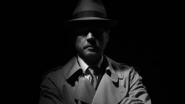 Noir film investigator standing in the dark
