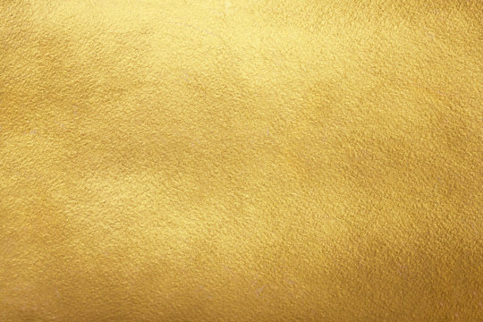 Gold background. Rough golden texture. Luxurious gold paper template for text design, lettering.