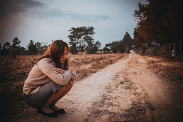 Portrait of lonely woman alone in a field. Vintage filter style.she heartbreak from love,sad girl concept on sunset vintage style