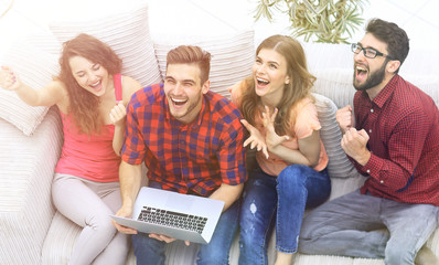 Fototapeta na wymiar group of friends watching a video on a laptop and laughing