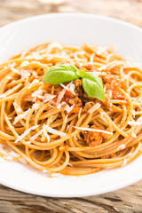 Piatto di spaghetti condito con carne, pomodoro e parmigiano 