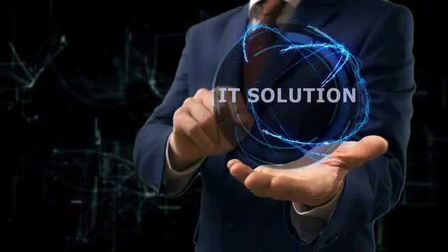 Businessman shows concept hologram IT solution on his hand. Man in business suit with future technology screen and modern cosmic background