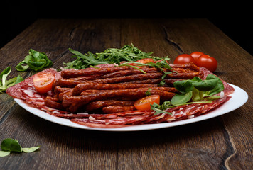 A plate with different types of sausage on a wooden table