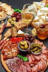 Cold meat cheese plate with salami chorizo sausage, prosciutto, cheese and wine