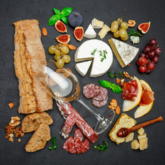 various types of cheese, meat, fruits and wine