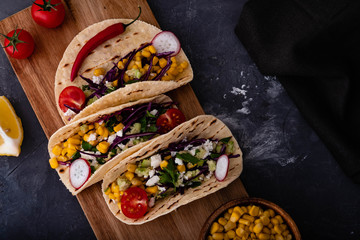 Pulled pork tacos with red cabbage, tomatoes, corn, feta and avocados overhead shot.