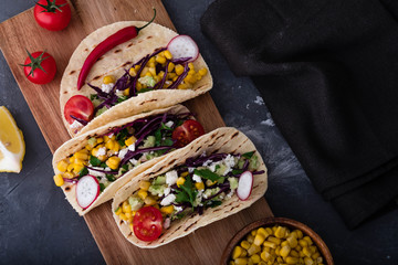 Pulled pork tacos with red cabbage, tomatoes, corn, feta and avocados overhead shot.
