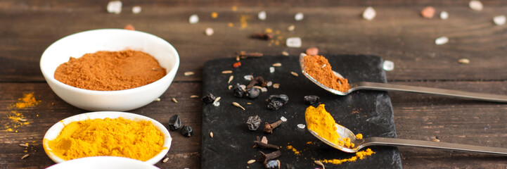 Spices and herbs. Variety of spices and herbs on a dark wooden surface