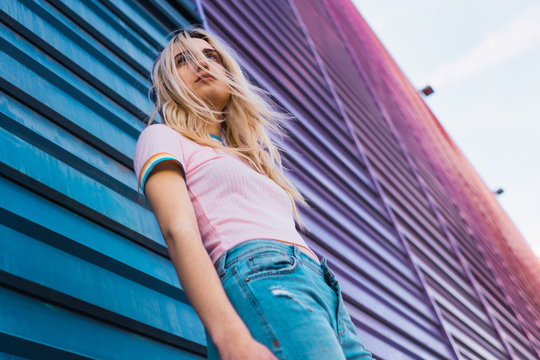 Low angle view of young woman standing against wall