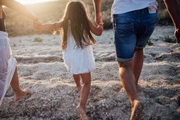 Young happy family walking along the seashore