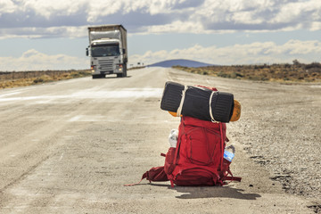 Red backpack in the road with truck in the background