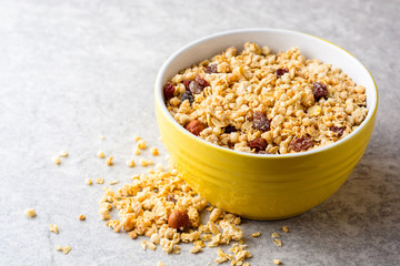 Granola and muesli in bowl on gray stone background