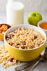 Granola and muesli in bowl on gray stone background