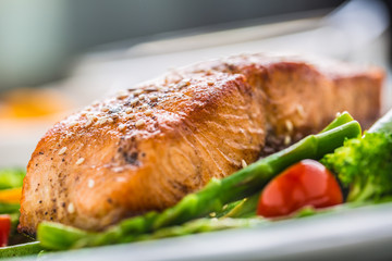 Roasted salmon steak with asparagos broccoli carrot tomatoes radish green beans and peas. Fish meal with fresh vegetable