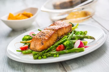 Fototapeten Roasted salmon steak with asparagos broccoli carrot tomatoes radish green beans and peas. Fish meal with fresh vegetable © weyo