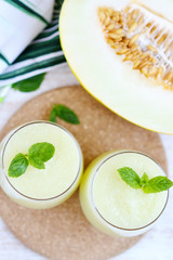 Cold fresh melon smoothies with mint in glass, summer drink beverage, healthy food concept, freshness, exotic fruits