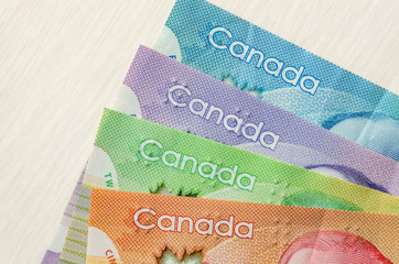 Obraz premium Colourful canadian dollar banknotes on wooden background