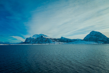 Outdoor view of beautiful mountain partial covered with snow, the in Hurtigruten region in Norway