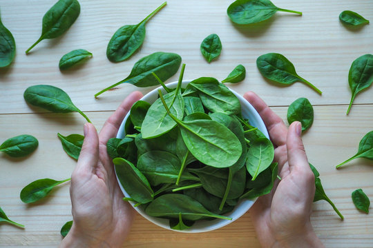Fresh spinach leaves on a wooden table.
