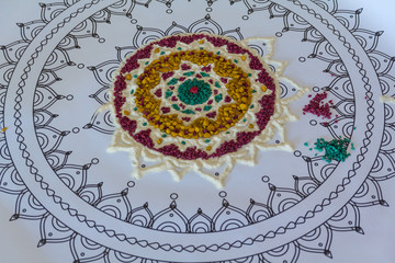 Painted mandala in the course of creation. Vedic culture