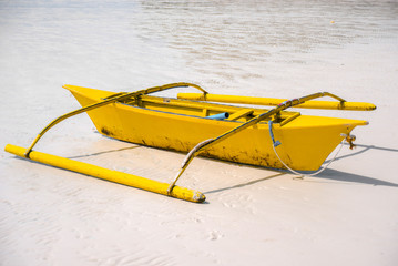 Small yellow bangka boat on the sandy beach, Philippines