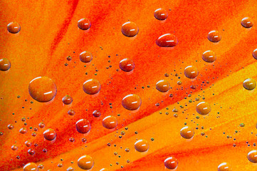 Round water droplets background with a pattern of pixels in a striped orange colour.
