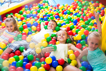 Fototapeta na wymiar kids playing with multicolored plastic balls .