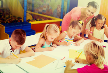 Fototapeta premium Positive children drawing on lesson in class