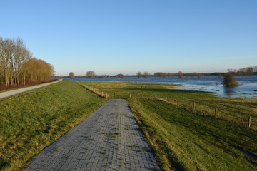 een toegangsweg naar weiland bij overstroomde IJssel