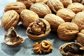 Walnut kernels and whole walnuts on rustic old table