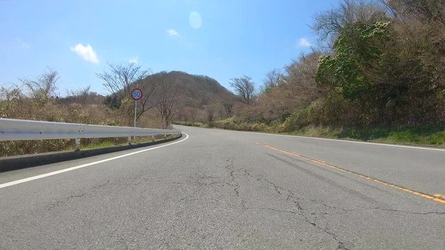 Driving on winding mountain road in spring