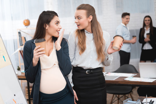 Two young girls are spreading gossip on coffee break. Gossip in the office.