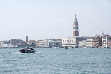 Fototapeta na wymiar Venice, Italy: a public transport boat, called vaporetto, goes towards Palazzo Ducale and Piazza San Marco