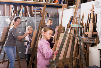 schoolgirls diligently training their painting skills during class at art studio