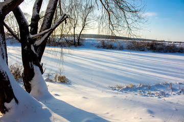 Panorama of a snow-covered river in a winter's day
