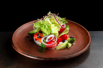 Fresh caesar salad in clay plate.