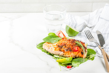 Grilled salmon steak filet with fresh vegetables, spinach and lime, white marble table copy space