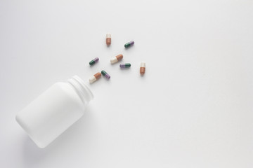 Assorted pharmaceutical medicine pills, tablets and capsules and bottle on white background. Copy space for text