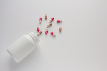 Assorted pharmaceutical medicine pills, tablets and capsules and bottle on white background. Copy space for text