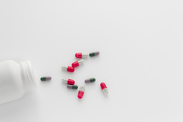 Assorted pharmaceutical medicine pills, tablets and capsules and bottle on white background. Copy space for text