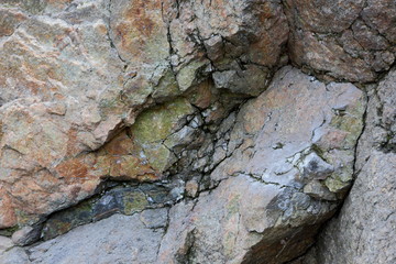 Granite rocks with faults, a background of old stones, tectonic movements, destruction of a granite wall, erosion, ecological problems of the planet Earth, climate change, a natural pattern