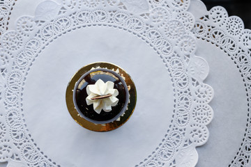 Little cake with white glase and slice of chocolate on top of it