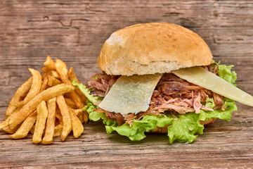 Barbeque Pulled pork Sandwich with green salad,caramelized onion,cheese,Sauce and Fries on wooden background,Fast food
